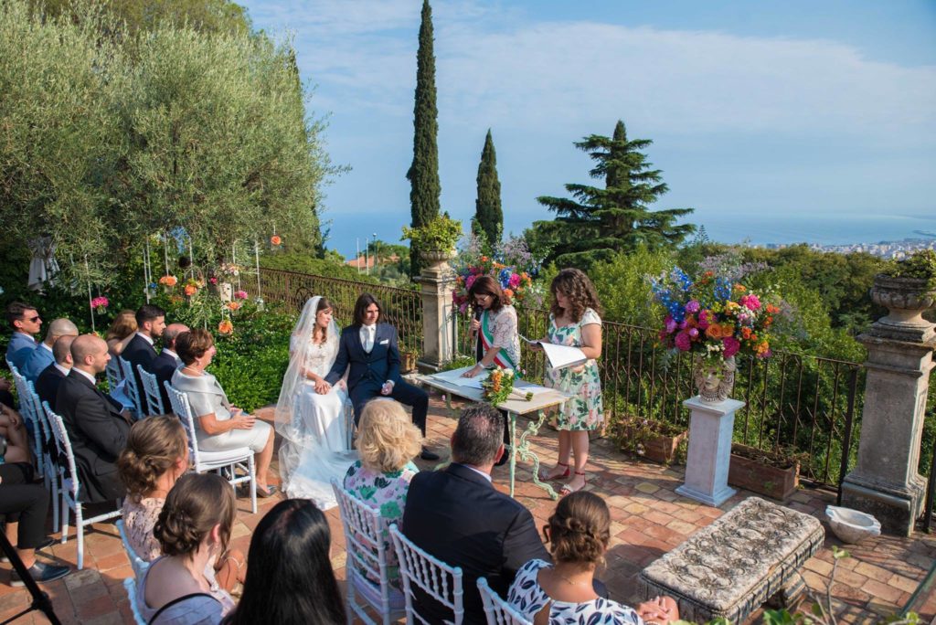 Bruidspaar tijdens ceremonie op terras met uitzicht over zee en Catania