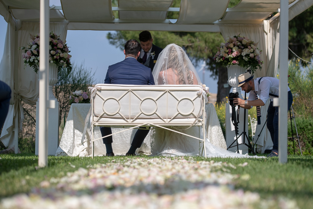bruidspaar zittend op bruidsbankje tijdens trouwceremonie bij Castello Camemi Sicilië