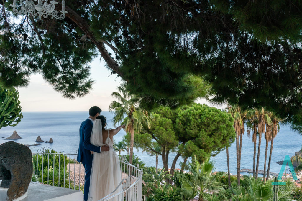 bruidspaar op terras bij Casa delle Terre Forti uitkijkend over de zee bij Aci Castello