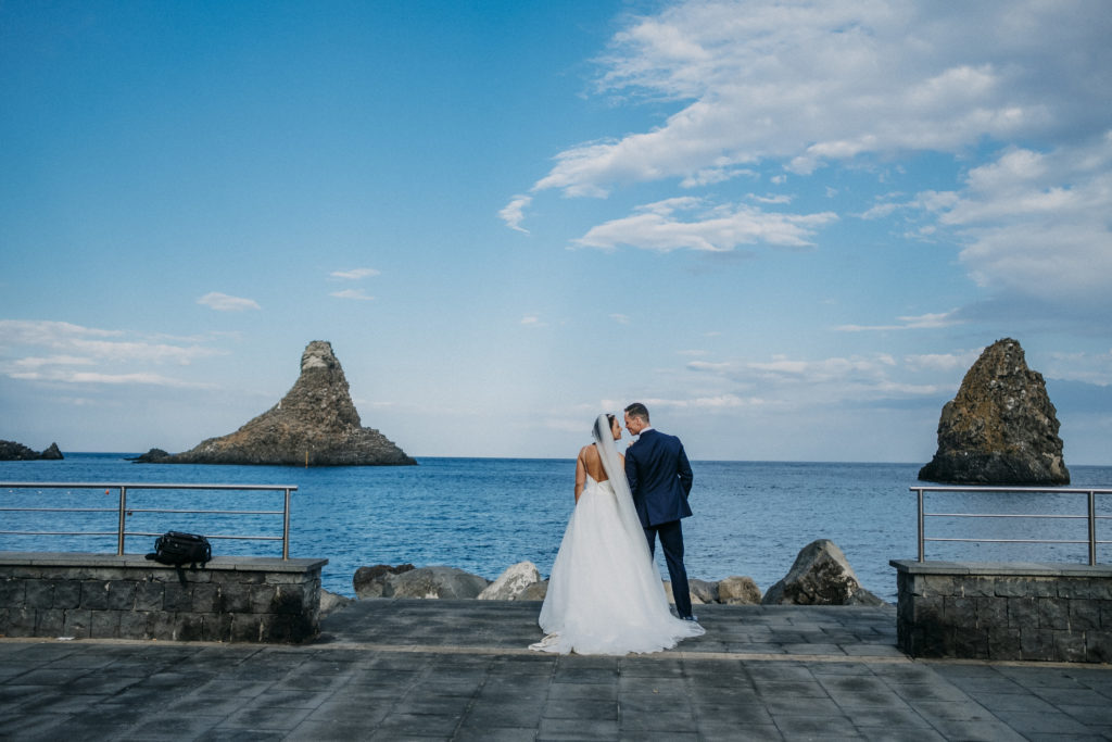 bruidspaar aan de zee in Aci Castello Sicilië